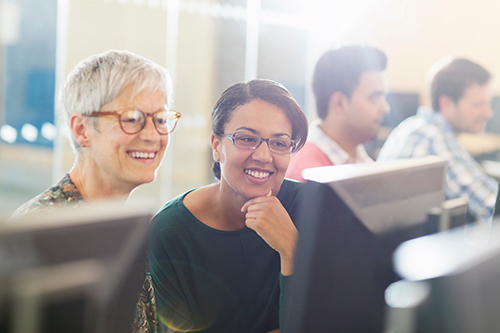 Two women looking at a computer screen.