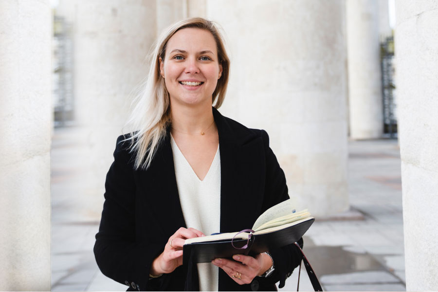 A student smiles while flipping through her book on law.